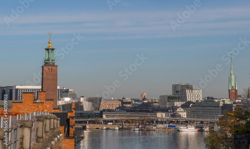 Hill view over the Town City Hall and the down town district at the Central Station waterfront pier with steam commuting boats an sunny autumn day in Stockholm