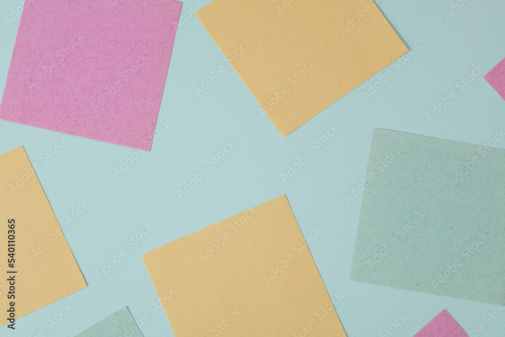 Colored blank memo papers on a blue background Colored blank memo papers on a blue background