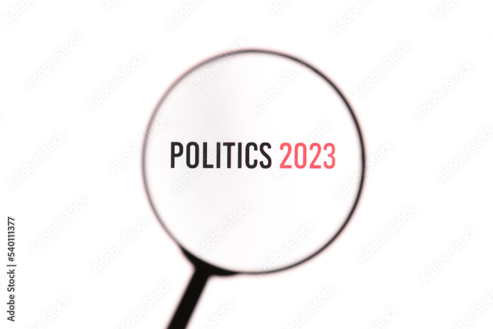 Phrase Politics 2023 through a magnifying glass on a white screen background. Phrase Politics 2023 through a magnifying glass on a white screen background.