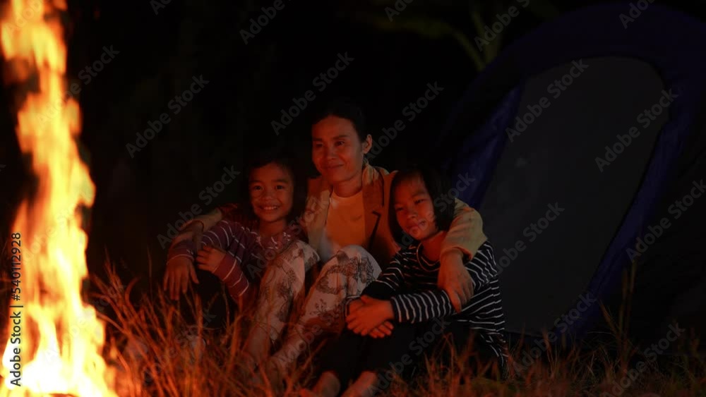 Slow motion mother and children on fire camp of dark night sky background