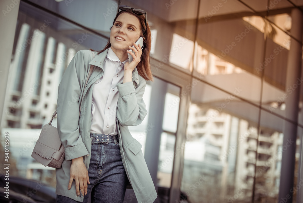 Young smiling woman talking on phone against blue windows background. Lifestyle Young smiling woman talking on phone against blue windows background. Lifestyle