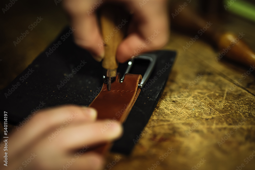 creating holes to hand sew metal buckle to the leather belt 