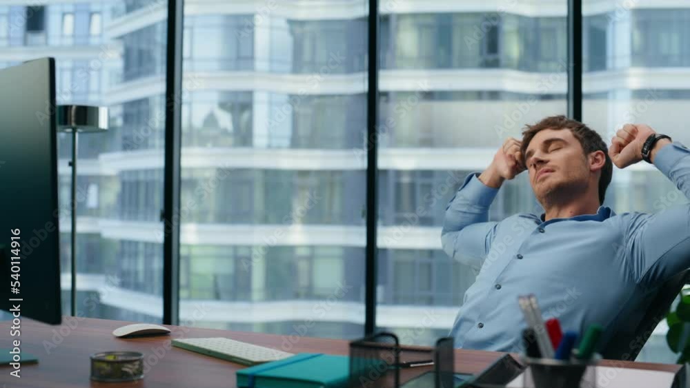 Rich man stretching body at office. Young businessman relaxing dreaming at break