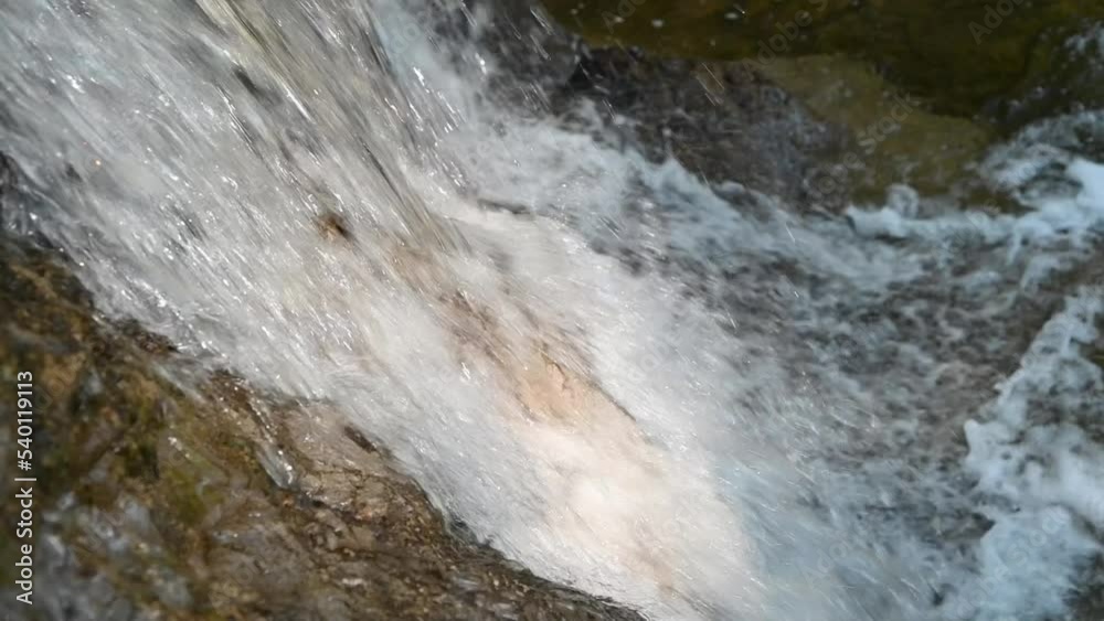 Closeup of a waterfall from a mountain stream (slow motion) Closeup of a waterfall from a mountain stream (slow motion)