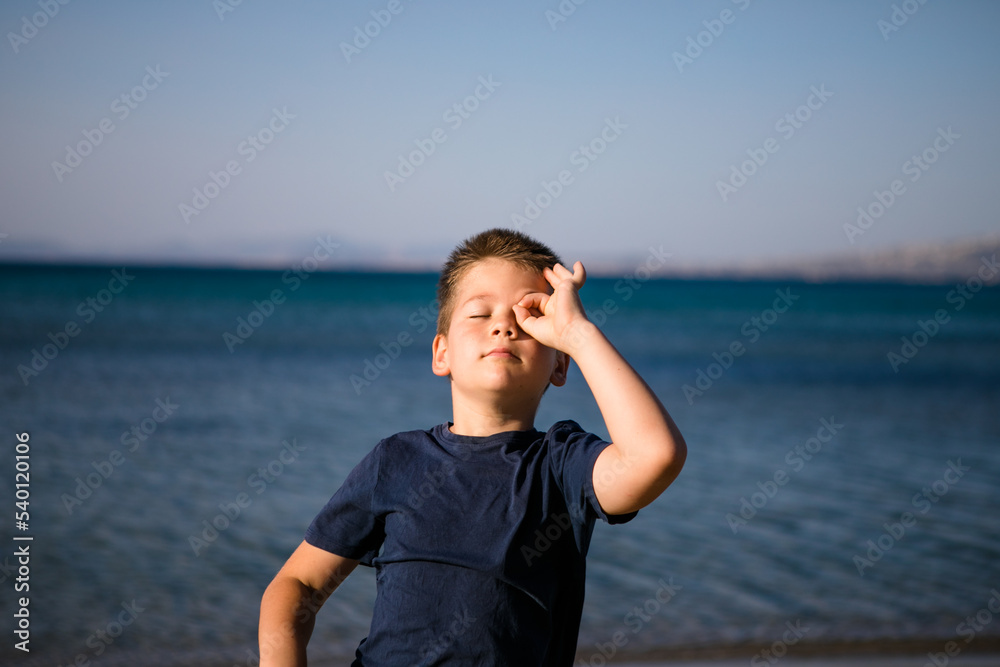 Boy playing on the beach on summer holidays. Children in nature with beautiful sea, sand and blue running in the sea water. Boy playing on the beach on summer holidays. Children in nature with beautiful sea, sand and blue running in the sea water.
