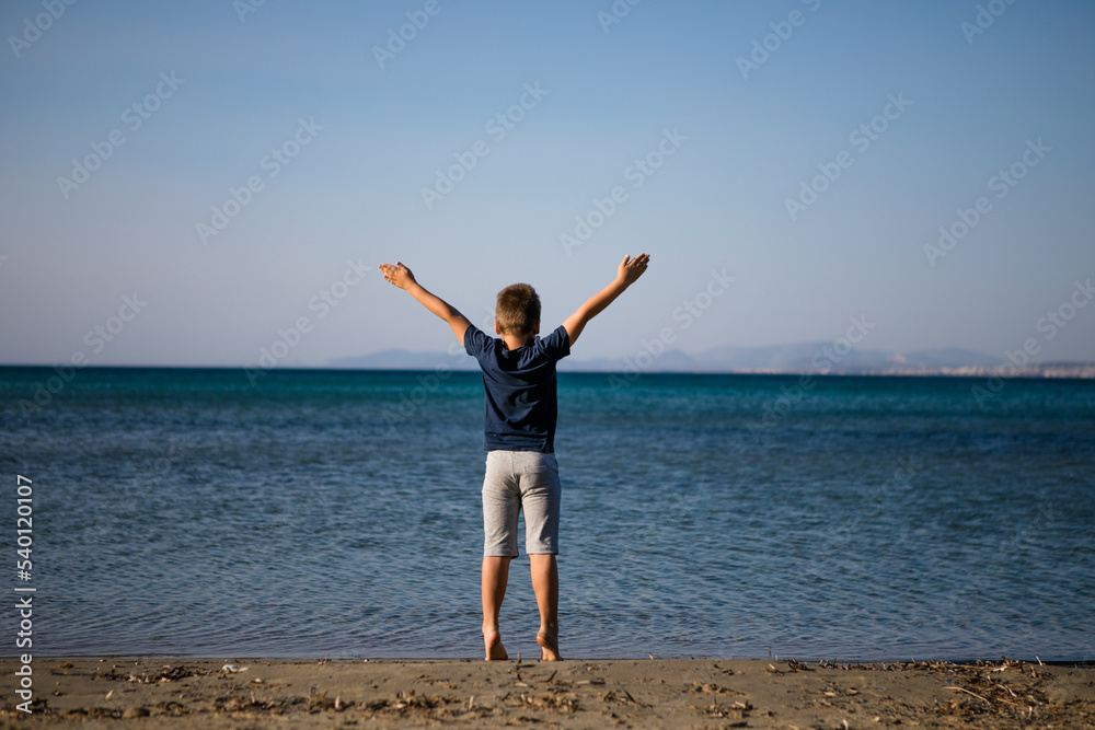 Boy playing on the beach on summer holidays. Children in nature with beautiful sea, sand and blue running in the sea water. Boy playing on the beach on summer holidays. Children in nature with beautiful sea, sand and blue running in the sea water.