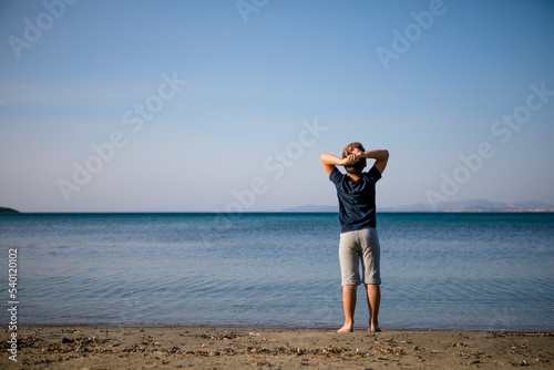 Boy playing on the beach on summer holidays. Children in nature with beautiful sea, sand and blue running in the sea water.