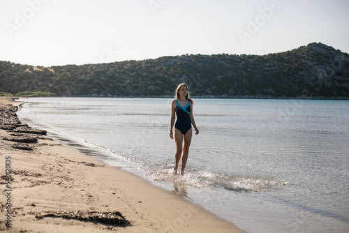Young woman playing in the sea in summer. woman enjoying in sea water.Cheerful young woman having fun on the beach. She is relaxed in the sea water and enjoys on vacation.