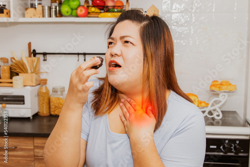 Foto Fat woman voraciously eats chocolate sweets and has difficulty swallowing food stuck in her throat obstructed her suffocated speak without sound have cyanosis