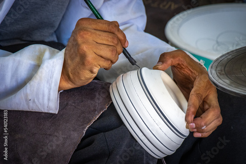 close up of a person painting ceramics, medina of fez, fes, fez el bali, morocco, north africa, medina