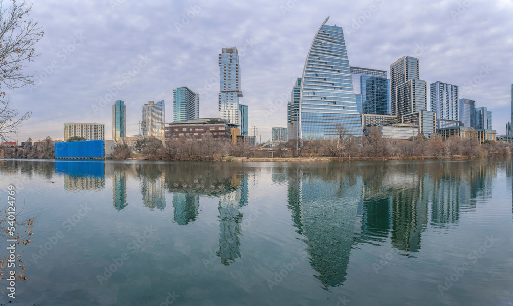 Austin Texas city skyline reflected on the calm pond water against cloudy sky