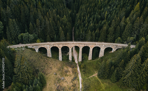 Railway bridge - Viaduct of Telgart in Europe Slovakia from above (top view) with beautiful pine forest and path under the viaduct. Aerial photo of train railways by drone - wide angle view.