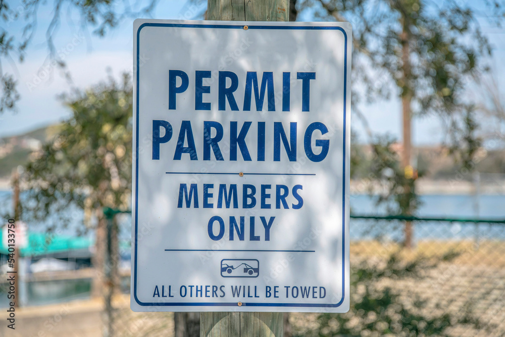Permit Parking Members Only sign against blurry view of Lake Austin in Texas Permit Parking Members Only sign against blurry view of Lake Austin in Texas