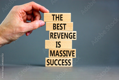 Revenge or success symbol. Concept words The best revenge is massive success on wooden blocks. Bussinesman hand. Beautiful grey background. Business and revenge or success concept. Copy space. photo