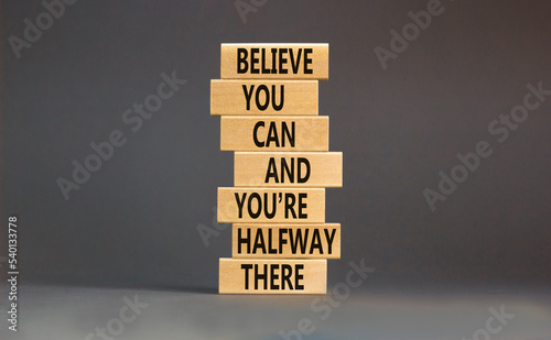 You can symbol. Concept words Believe you can and you are halfway there on wooden blocks on a beautiful grey table grey background. Business motivational and you can concept.