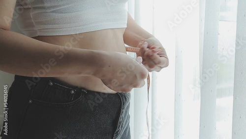 Beautiful fat woman with tape measure She uses her hand to squeeze the excess fat that is isolated on a white background. She wants to lose weight, the concept of surgery and break down fat under the