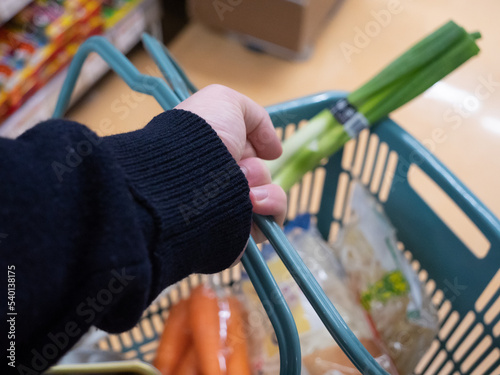 A young man's hand holding a shopping basket