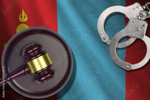 Mongolia flag with judge mallet and handcuffs in dark room. Concept of criminal and punishment, background for judgement topics photo