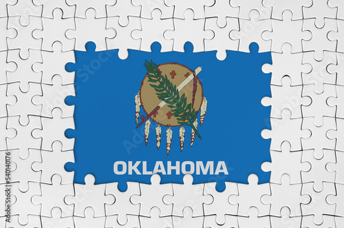 Oklahoma US state flag in frame of white puzzle pieces with missing central part photo