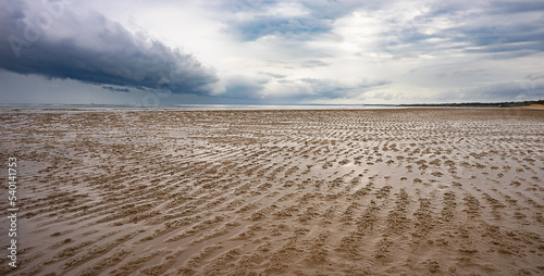 Sand flats of the intertidal zone of Pialba Beach, Queensland, at low tide with a storm approaching Hervey Bay. photo