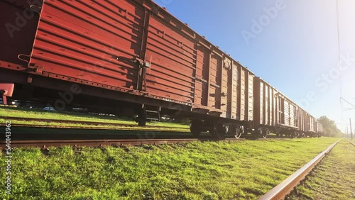 Railway freight train stands at the railway junction on a sunny summer day. Wide angle shot photo