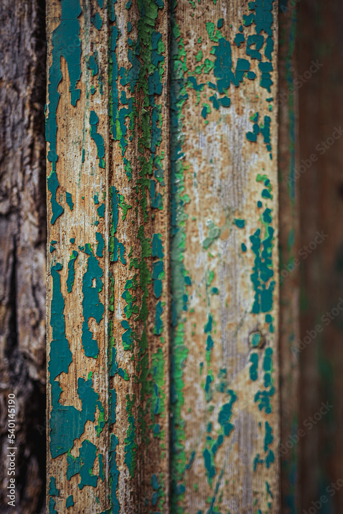 Obraz premium A wooden door frame with paint scratched off in a derelict old place. Blue residues of peeling paint.