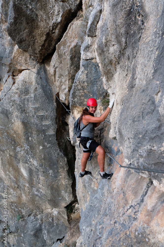 Man in helmet climbing on a rock. Rock climber training