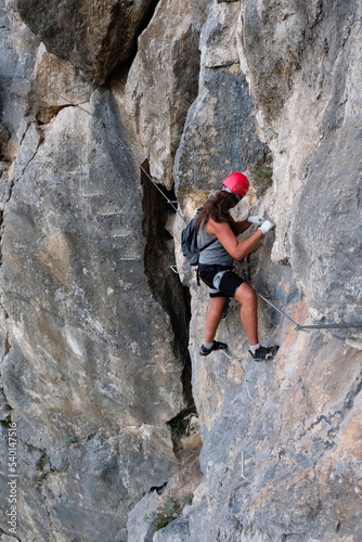 Man in helmet climbing on a rock. Rock climber training
