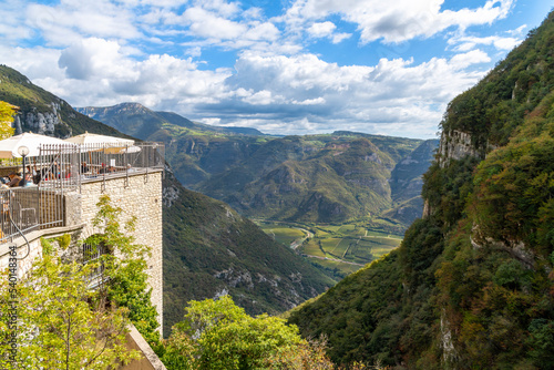 View from the cliffside stone Santuario de la Madonna della Corona sanctuary, monastery and church complex with the outdoor restaurant patio overlooking the mountains and valley in Spiazzi, Italy.