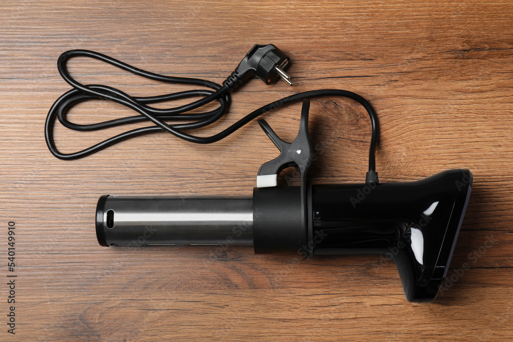 Thermal immersion circulator on wooden table, top view. Sous vide cooker Thermal immersion circulator on wooden table, top view. Sous vide cooker