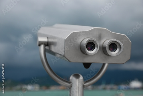 Metal tower viewer installed near sea, closeup. Mounted binoculars