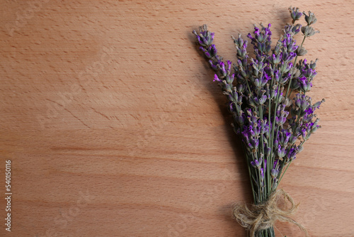 Bouquet of beautiful lavender flowers on wooden table  top view. Space for text