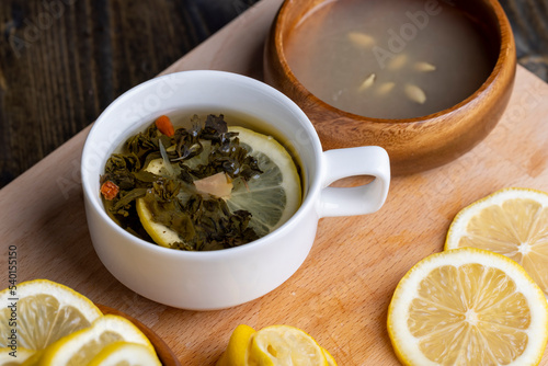 Green tea in a white cup during its brewing