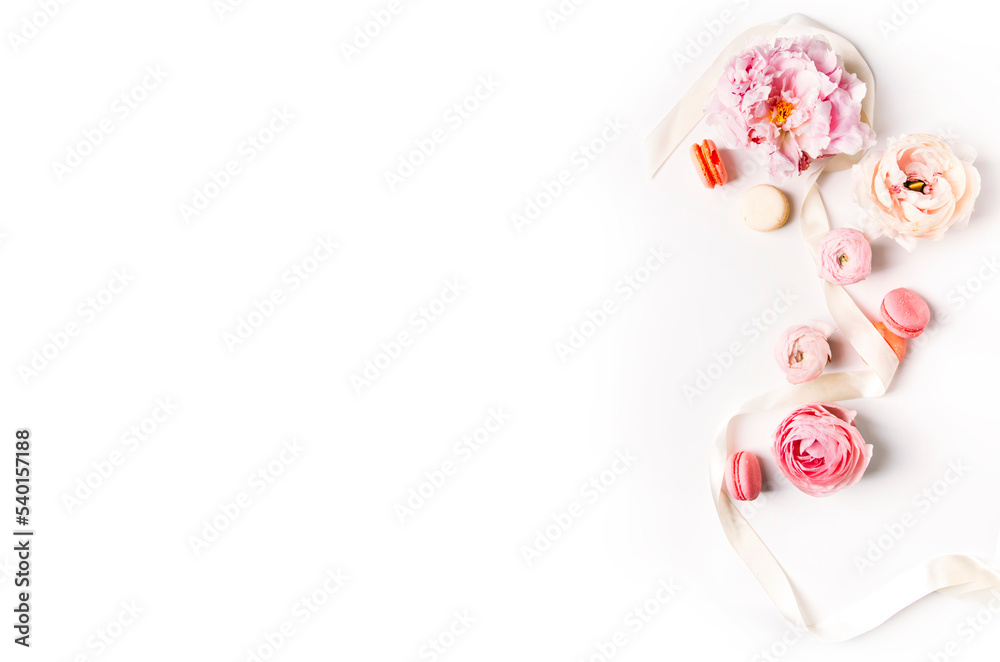 Top view of pink peonies and macaroons on a light background, a place for text