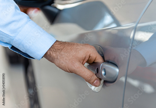 Close up of a male customer hand opening a car door at the dealership