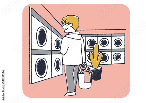 コインランドリーで洗濯をする男性