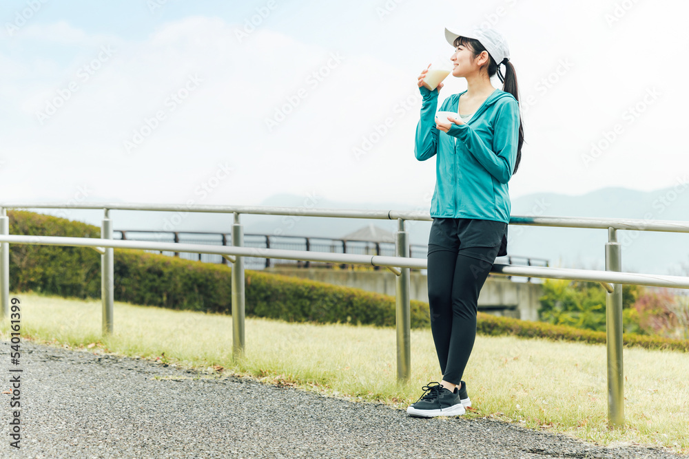 ボディメイクのため公園でプロテインを飲みながらトレーニングするスポーツウェアのアジア人女性
ボディメイクのため公園でプロテインを飲みながらトレーニングするスポーツウェアのアジア人女性