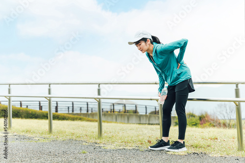 ランニング・ウォーキング中に腰痛になる体調不良のアジア人女性
 photo