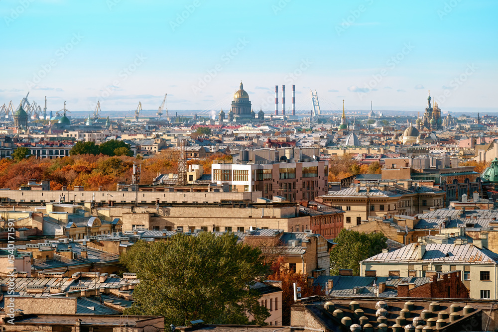 Cityscape on an autumn day. The roofs of a European city have been removed from the observation deck. Rooftops of houses and buildings, crowns of autumn trees taken from a great height.