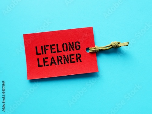 Red tag on blue background with text LIFELONG LEARNER, concept of people who focus on continual learning of new in-demand skills empower personal development, by informal education