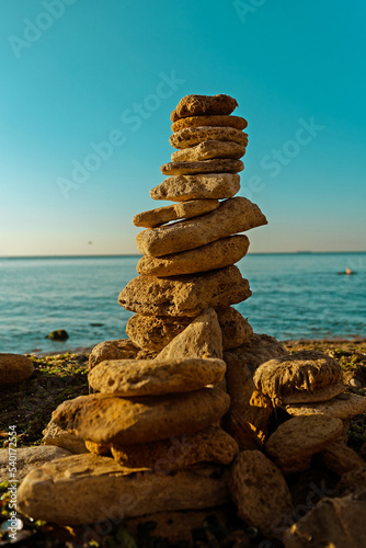 Laying beach stones balancing rocks on a sand seashore