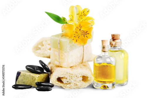 Healthy spa concept with handmade soap bars, oil bottles, sponge and flowers