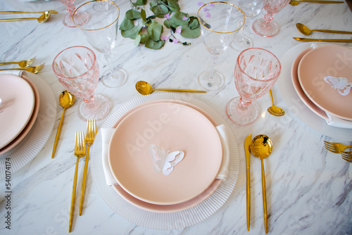 Decoración elegante de mesa con vajilla platos, cubiertos y plantas