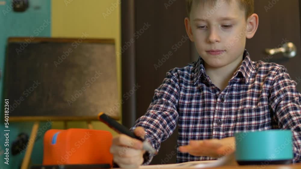 Home technology child education concept to help.Caucasian boy 7 years old at home doing homework using smart speaker.smart speaker is used by children.educational program Home technology child education concept to help.Caucasian boy 7 years old at home doing homework using smart speaker.smart speaker is used by children.educational program