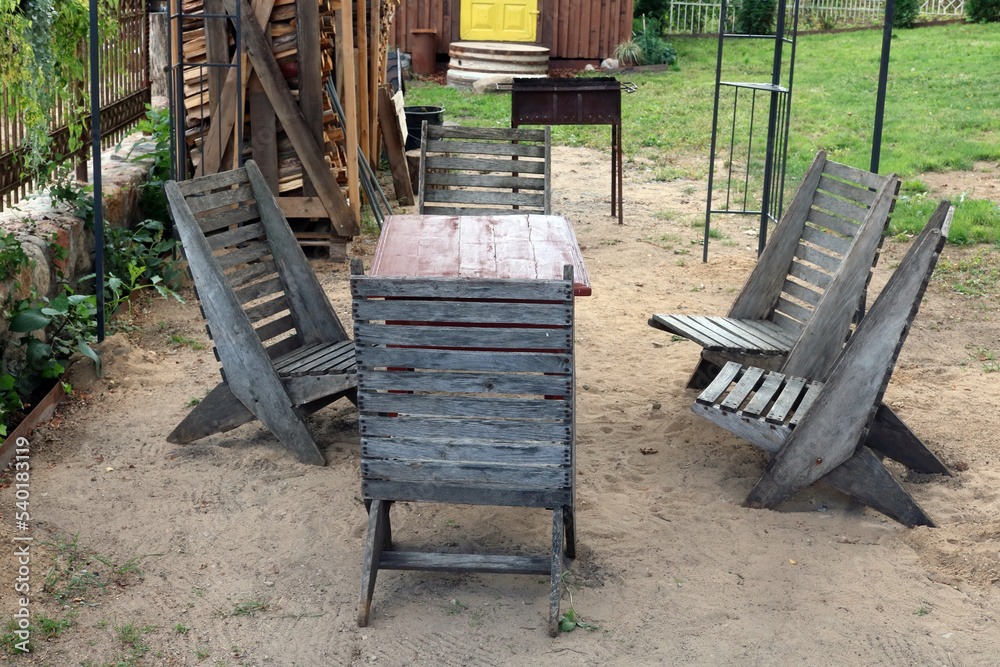 Recreation area on a village - a wooden table and a bench for a barbecue Recreation area on a village - a wooden table and a bench for a barbecue