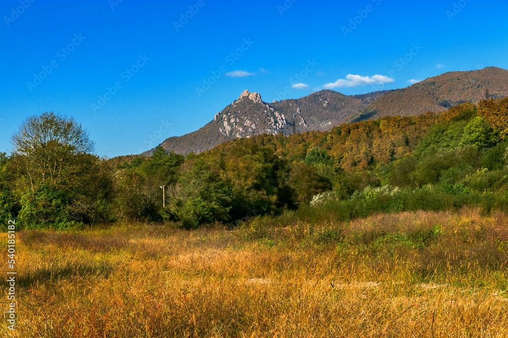 Field and forest on the background of Mount Indyuk (859 meters), located on the territory of the forest reserve. The surroundings of the mountain are very popular among rock climbers.