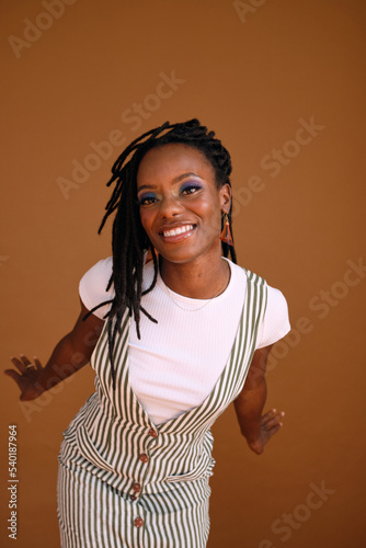 Studio portrait of young beautiful woman with dreads and rollerskates
 photo