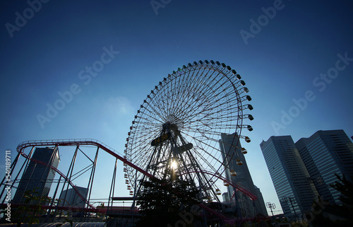 Urban Ferris wheel on a clear blue sky day