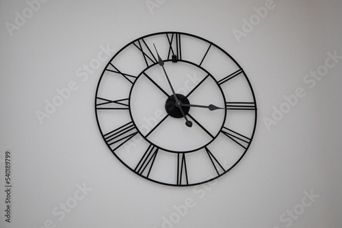Vintage black steel Old big roman numerals Clock in wall home interior house