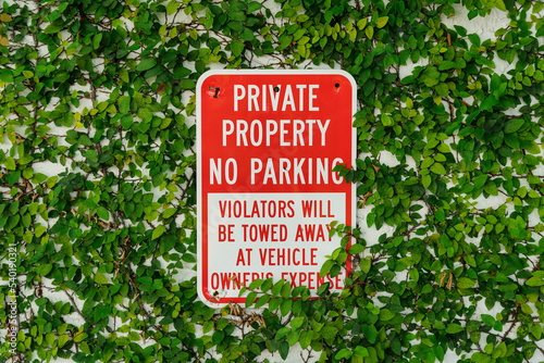 Private Property No Parking sign against wall with leaves in Destin Florida
